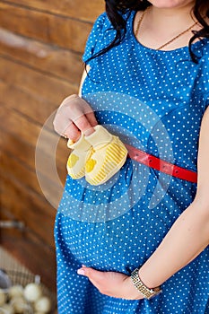 Pregnancy, motherhood and happy future mother concept. Pregnant woman holding her belly studio