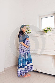 Pregnancy, motherhood, people and expectation concept - close up of happy pregnant woman with big belly indoors