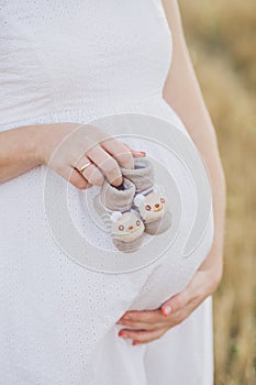 Pregnancy, motherhood, people and expectation concept - close up of happy pregnant woman with big belly on nature