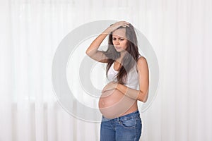 Pregnancy, motherhood, people and expectation concept - close up of happy pregnant woman with big belly at window