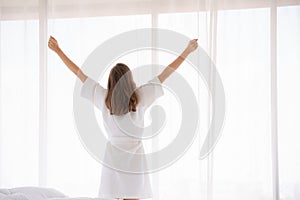 Pregnancy, motherhood, people and expectation concept - close up of happy pregnant woman opening window curtains