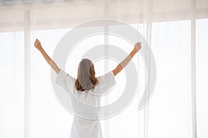 Pregnancy, motherhood, people and expectation concept - close up of happy pregnant woman opening window curtains