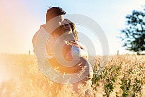 Pregnancy, motherhood, people and expectation concept, couple together in field during sunset