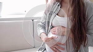 Pregnancy, motherhood, people, expectation concept - happy pregnant woman touching her tummy in bed at home caring