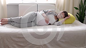 pregnancy, motherhood, people, expectation concept - happy tired sleepy pregnant woman touching her tummy sleep resting