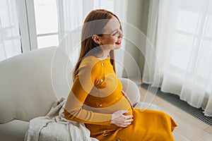 Pregnancy motherhood people expectation future. Pregnant woman with big belly sitting on chair near window at home. Girl