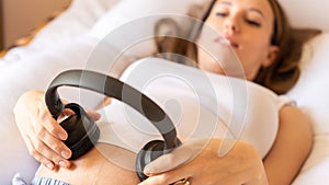 Pregnancy music woman listen. Pregnant woman listening to music. Mother belly listen headphones sound. Concept of