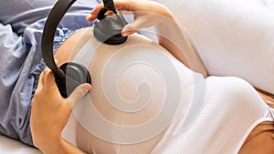 Pregnancy music woman listen. Pregnant woman listening to music. Mother belly listen headphones sound. Concept of