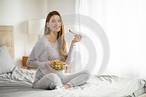 Pregnancy Nutrition. Pregnant Woman Eating Salad While Sitting On Bed At Home