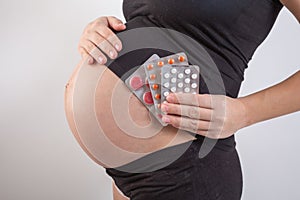 Pregnancy, people and health care concept - close up of pregnant woman. vitamins and minerals for pregnant women. Taking