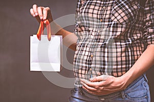 pregnancy shopping, motherhood, people and expectation concept - pregnant woman with shopping bag touching her big belly