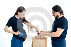 pregnancy, shopping, parenthood and happiness concept - happy young family with shopping bags