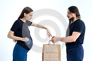 pregnancy, shopping, parenthood and happiness concept - happy young family with shopping bags