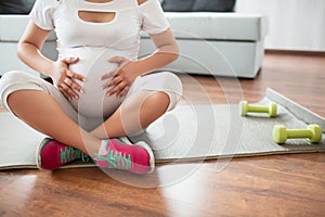 Pregnancy, sport, yoga, people and healthy lifestyle concept - happy pregnant woman meditating at home