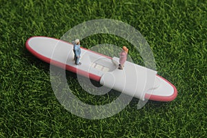 Pregnancy test pack positive result at green grass and family miniature figure