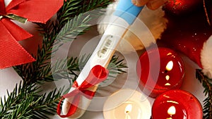 Pregnancy test positive result best present for parents and grandparents merry Christmas candles burning hand placing putting wait