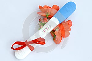 pregnancy test positive result with flower and present red ribbon