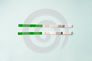 Pregnancy test strips, one and two strips on a blue background