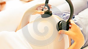 Pregnancy therapy music. Pregnant woman listening to music. Mother belly listen headphones sound. Pregnancy, medicine