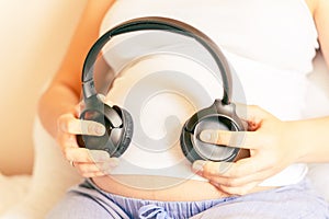 Pregnancy therapy music. Pregnant woman listening to music. Mother belly listen headphones sound. Pregnancy, medicine