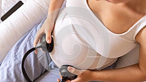 Pregnancy therapy music. Pregnant woman listening to music. Mother belly listen headphones sound. Pregnancy, medicine