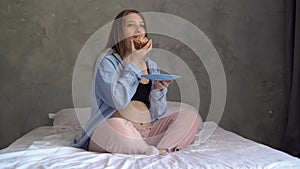 Pregnancy and unhealthy eating concept. pregnant woman holds a plate with tasty cupcake or muffin. Unhealthy and calorie