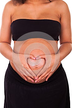 Pregnant african american woman hands on belly forming a heart