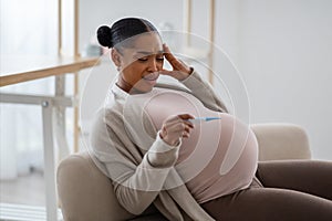 Pregnant African American Woman Holding Thermometer Measuring Temperature
