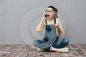 Pregnant angry screaming woman talking by mobile phone.