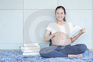 Pregnant Asian moms Reading a book and looking at the camera
