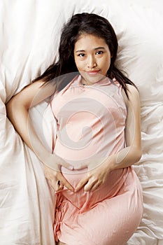 Pregnant Asian Woman on a comfortable bedroom