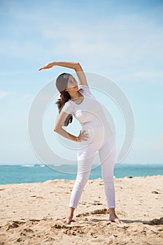 Pregnant asian woman exercise in the beach