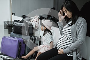 Pregnant asian woman feel dizzy and his daughter when in the waiting room airport