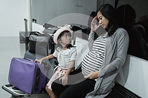 Pregnant asian woman feel dizzy and his daughter when in the waiting room airport