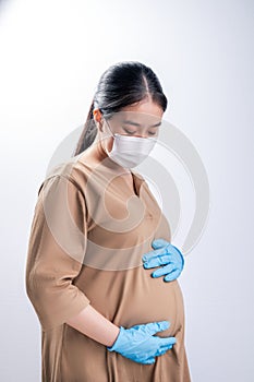 Pregnant asian woman in medical mask for protect coronavirus covid-19