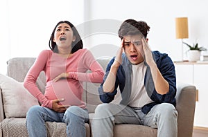 Pregnant Asian Woman Screaming Having Spasm Sitting With Husband Indoors