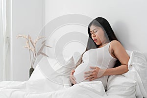 Pregnant asian woman suffering from back pain.