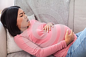 Pregnant Asian Woman Touching Belly Having Painful Contractions At Home