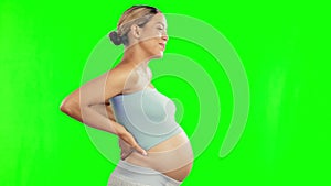 Pregnant, back pain and woman with cramps on green screen with maternity problem, worry and stress. Pregnancy, health
