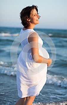Pregnant beach walking female relaxing