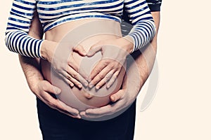 Pregnant Belly with Heart Symbol. Man Hugging Pregnant Woman