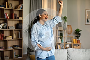 Pregnant Black Female Dancing And Singing Having Fun At Home