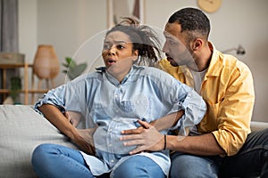 Pregnant Black Lady Having Labor Pains Sitting With Husband Indoor