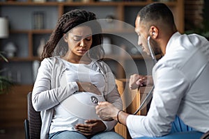 Pregnant black woman feeling bad, visiting doctor
