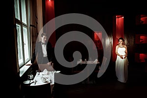 Pregnant bride walks in the cafe to the groom waiting for her