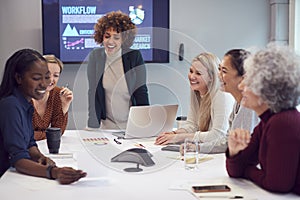 Pregnant  Businesswoman Leads Creative Meeting Of Women Collaborating Around Table In Modern Office