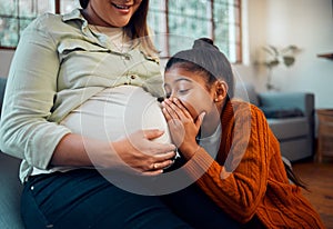 Pregnant, children and stomach with a mother and daughter whispering to a sibling in a belly at home. Whisper, love and