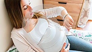Pregnant clock time childbirth. Childbirth time, contractions pain. Pregnancy woman watching clock, holding baby belly