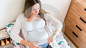 Pregnant contractions time. Pregnancy woman watching clock, holding baby belly. Childbirth time, contractions pain