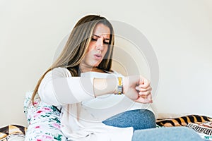 Pregnant contractions time. Pregnancy woman watching clock, holding baby belly. Childbirth time, contractions pain